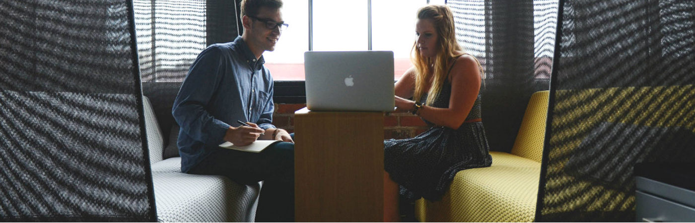 male and female researchers in discussion over laptop